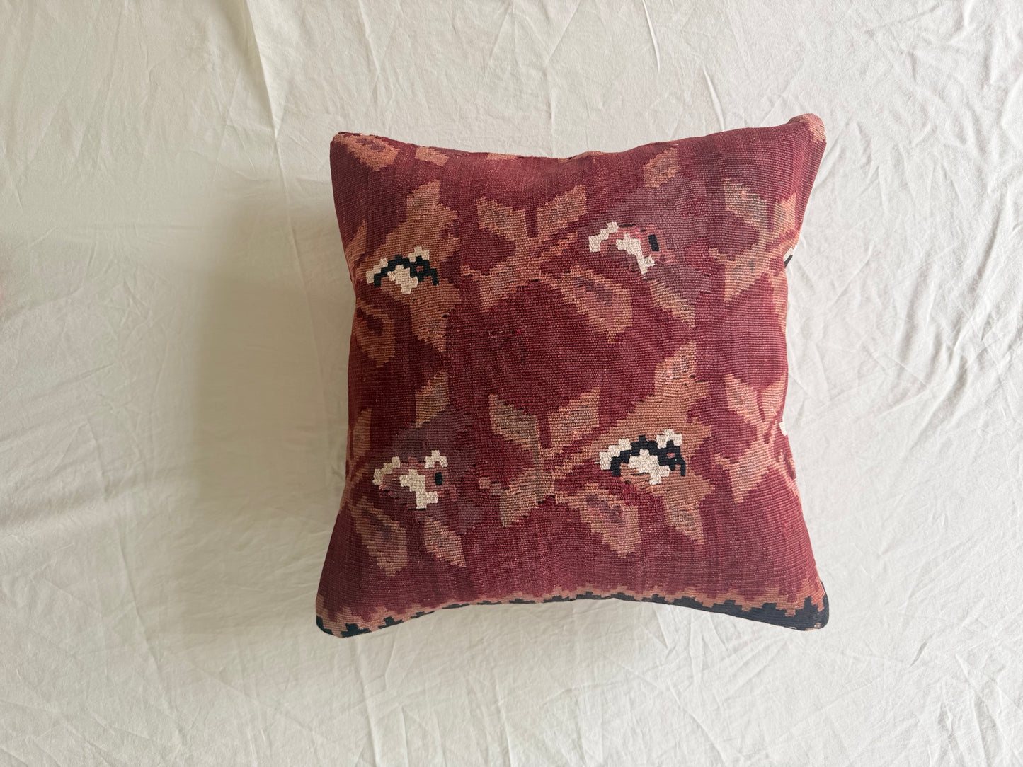 Decorative pillow with a floral pattern deep red