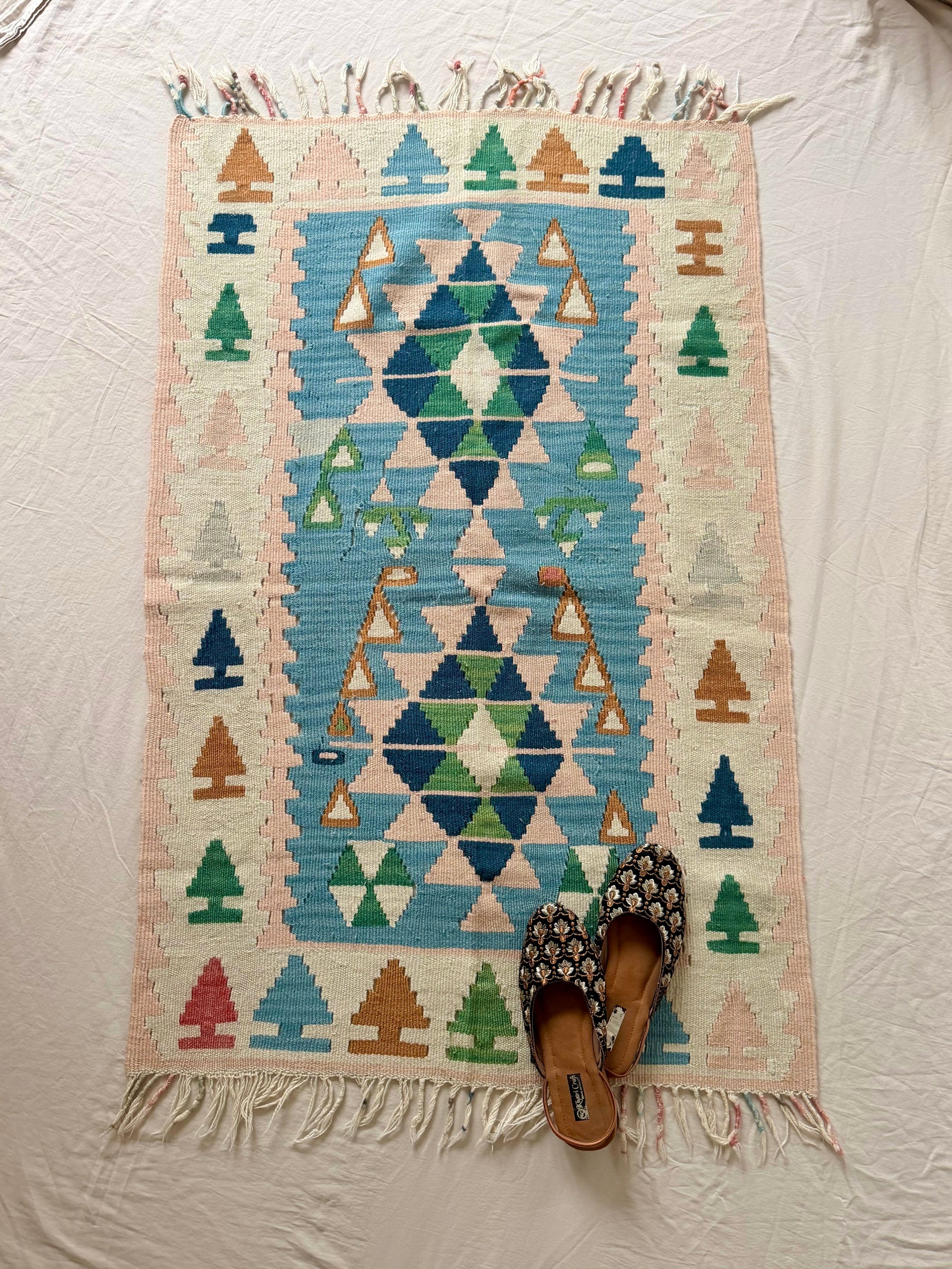 Geometric patterned rug with triangles on a plain background